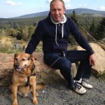 Mann und Hund in Torfhaus, im Hintergrund der Brocken