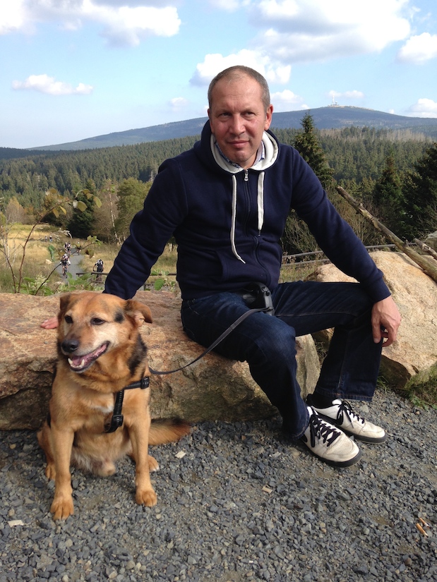 Mann und Hund in Torfhaus, im Hintergrund der Brocken