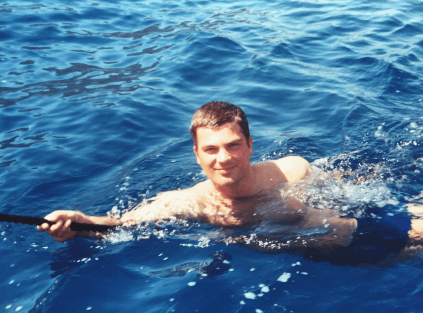 Junger Mann lässt sich von einer Segelyacht durch's Mittelmeer ziehen