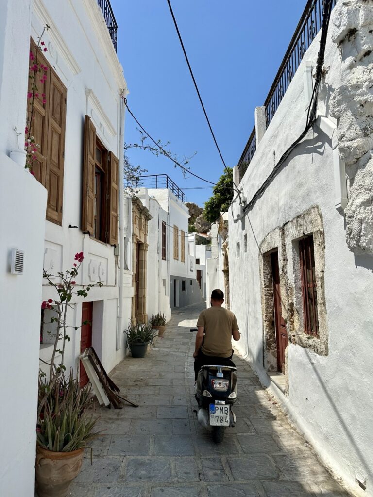 Die Einheimischen rasen mit dem Motorroller durch die engen Gassen von Lindos